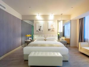 a bedroom with a large white bed and a couch at Jinjiang Metropolo Hotel - Taiyuan Economic Development Zone in Taiyuan +148 photos