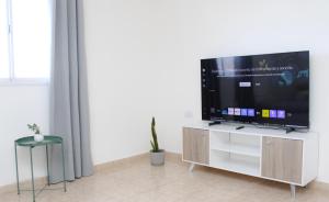 a living room with a flat screen tv on a cabinet at VL Apart in Villa Regina