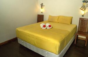 a yellow bed with two towels on top of it at Villa Sisi in Temukus +7 photos