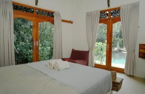 a bedroom with a bed and a large window at Villa Sisi in Temukus