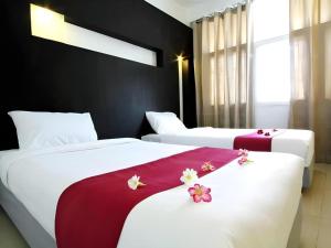 two beds in a hotel room with flowers on them at The Ratchathani Hotel in Ubon Ratchathani +54 photos