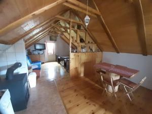 an attic room with a table and a dining room at Baške Oštarije - kuća za odmor in Brušane