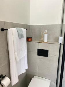 een badkamer met witte handdoeken en een toilet bij Nunu's Self Catering Apartment in Paarl +40 foto's