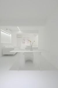 a white table with a vase of flowers on it at Daydreaming House under the Road in Chongqing