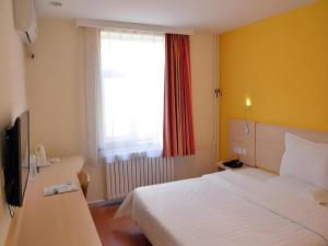 una camera da letto con un letto bianco e una finestra di 7 Days Inn Beijing Zhongguancun Suzhouqiao a Pechino