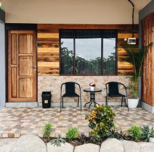 a patio with two chairs and a table in front of a door at Amal Zone Villa in Sungaipinang-besar +3 photos