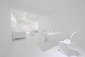 a white room with a white chair and tables at Daydreaming House under the Road in Chongqing