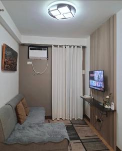 a living room with a couch and a television at Homestay Arezzo Place Davao - Building 9 in Davao City +30 photos