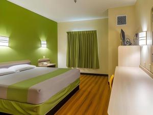 ein Schlafzimmer mit einem großen Bett und einer grünen Wand in der Unterkunft Econo Lodge Hot Springs South in Hot Springs