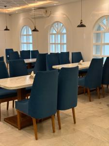 a conference room with blue chairs and tables at HOTEL DEO VOLENTE in Sivasagar