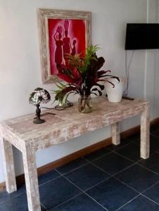 a table with a vase of flowers and a painting at Whispering Hills in Perean +27 photos