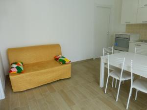 una camera con tavolo e divano e una sala da pranzo di A Due Passi dal Mare a Civitanova Marche