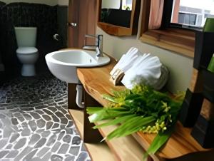 a bathroom with a sink and a toilet and a counter with flowers at Le Manumea Hotel in Tiavi +24 photos