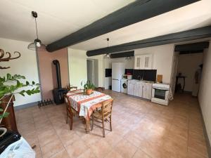 a living room with a table and a kitchen at Fabetmie in Mormoiron
