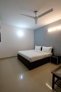 a bedroom with a bed and a ceiling fan at Hotel Vishnu in New Delhi