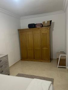 a room with a wooden cabinet with a suitcase on top at Chic furnished apartment, Center in Tangier +3 photos