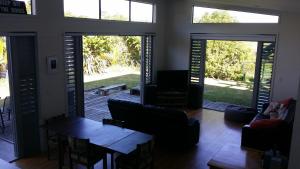 a living room with doors open to a patio at Tutukaka Coast Family Holiday House in Ngunguru +5 photos