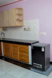 a kitchen with a black counter and wooden cabinets at Vidzo Royal Inn Hotel in Mtwapa