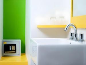 een keuken met een wastafel en een groene muur bij Amaris Hotel La Codefin Kemang in Jakarta +37 foto's