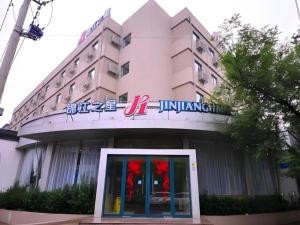 ein Gebäude mit einem Schild an der Vorderseite in der Unterkunft Jinjiang Inn Jinan Daming Lake in Jinan