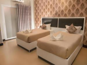 ローイエットにあるThe Premium Residenceのベッド2台と窓のある寝室