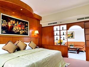 une chambre avec un grand lit avec un tableau au mur dans l'établissement Madani Hotel Medan, à Medan 134 autres photos