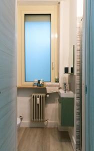 a bathroom with a window and a sink and a toilet at La tana di Pumba in Cuneo +10 photos