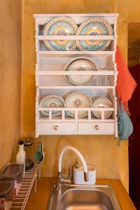 a kitchen with a sink and plates on the wall at Το Καμίνι, πέτρινη κατοικία πάνω στη θάλασσα The Kiln House Kamini, Retreat on the beach in Aspropótamos