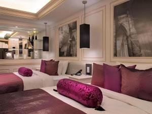 two beds in a room with purple and white at Hotel Piena Kobe in Kobe