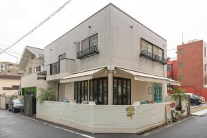 a white building with windows and a balcony at The Ivy Apartments, BEST Location, Yoyogi!! in Tokyo