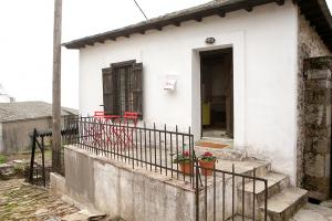 a small white house with a gate and a porch at The Pelion Manifesto 2 in Agios Georgios Nilias