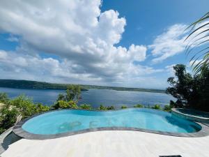 a swimming pool with a view of a lake at Limitless Tent Nusa Penida in Toyapakeh