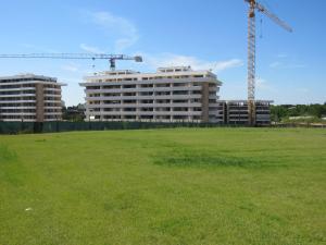 a large field with two tall buildings and a crane at Pianeta Roma 45 in Rome