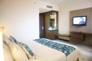 a bedroom with a bed with a television on a wall at Kedaton Hotel in Bandung