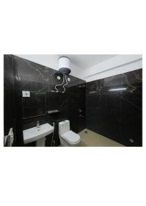 a bathroom with a toilet and a sink at Hotel Stayzzy Bloom in Noida