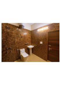 un baño con inodoro y lavabo en Hotel Stayzzy Bloom, en Noida