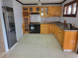 a kitchen with wooden cabinets and a black appliance at Bel Canto Lodge in Fombeni