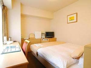 a hotel room with two beds and a television at Kushiro Royal Inn in Kushiro