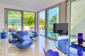 a living room with blue chairs and a tv at The Oscar in Baška