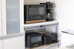 a tv sitting on top of a white shelf at 湘南sajima stay in Yokosuka