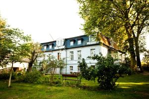 a large white house with a bench in the yard at Gut Boltenhof in Fürstenberg-Havel