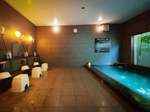 a swimming pool in a room with chairs at Super Hotel Arai-Niigata in Arai