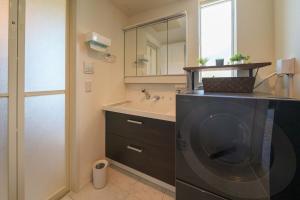 a bathroom with a sink and a washing machine at 湘南sajima stay in Yokosuka +50 photos