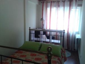 1 dormitorio con 1 cama con manta verde y ventana en Casa Entre Serras, en Donas