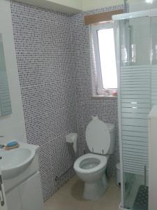 a bathroom with a toilet and a sink and a window at Casa Entre Serras in Donas