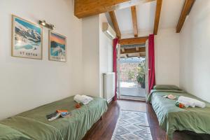 twee eenpersoonsbedden in een kamer met een raam bij Riva's Rooftop Retreat - Happy Rentals in Riva del Garda