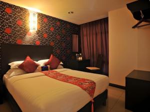 a bedroom with a large bed with red pillows at Sea Lion Hotel @ Klang in Klang