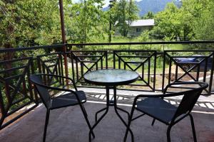 a table and chairs on a balcony with a fence at guesthause Tba Inn in Borjomi