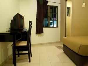 1 dormitorio con escritorio, ordenador y cama en Hotel Ria, en Johor Bahru