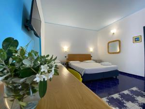 una camera con due letti e un tavolo con un vaso di fiori di Hotel Aura a Vulcano Altre 32 foto